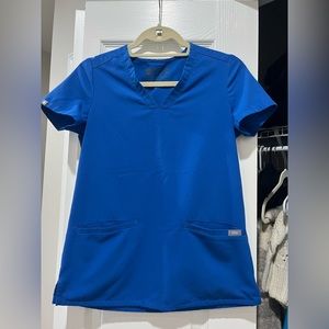 Sold****Royal blue figs scrub top, bilateral front pockets.
